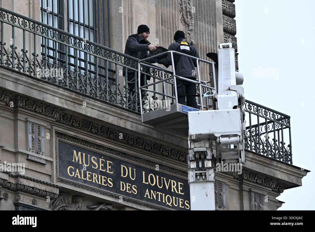 Workers install metal security bars over the window where thieves broke ...