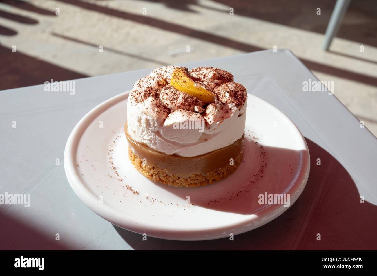 Banoffee pie dessert served on a plate in warm sunlight, highlighting creamy texture and caramel tones in a relaxed Mediterranean setting BirÅ¼ebbuÄa, Malta, 6 DEC 2025. Stock Photo