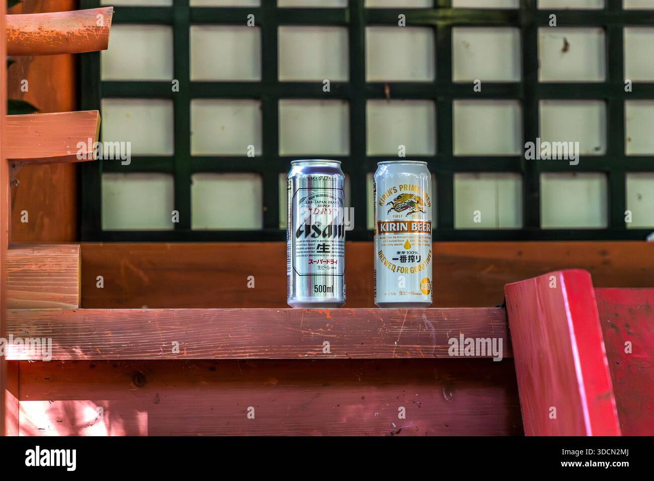 Two beer cans stand on a wooden beam at the Hosshinmon-oji shrine near Tanabe, Wakayama Prefecture, Japan. They are an offering, not carelessly discarded rubbish. The small shrine with its gate marks the outer entrance to the sacred precincts of Kumano Hongū Taisha. Stock Photo