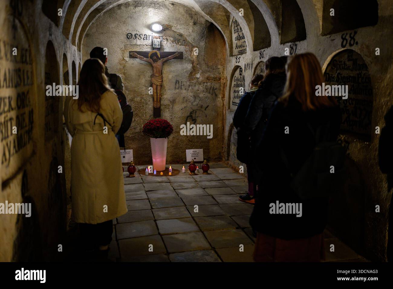 People pray in the crypt of the Seminary Church of St Anthony of Padua in Košice, Slovakia during the Octave of All Souls’ Day. - Stock Image