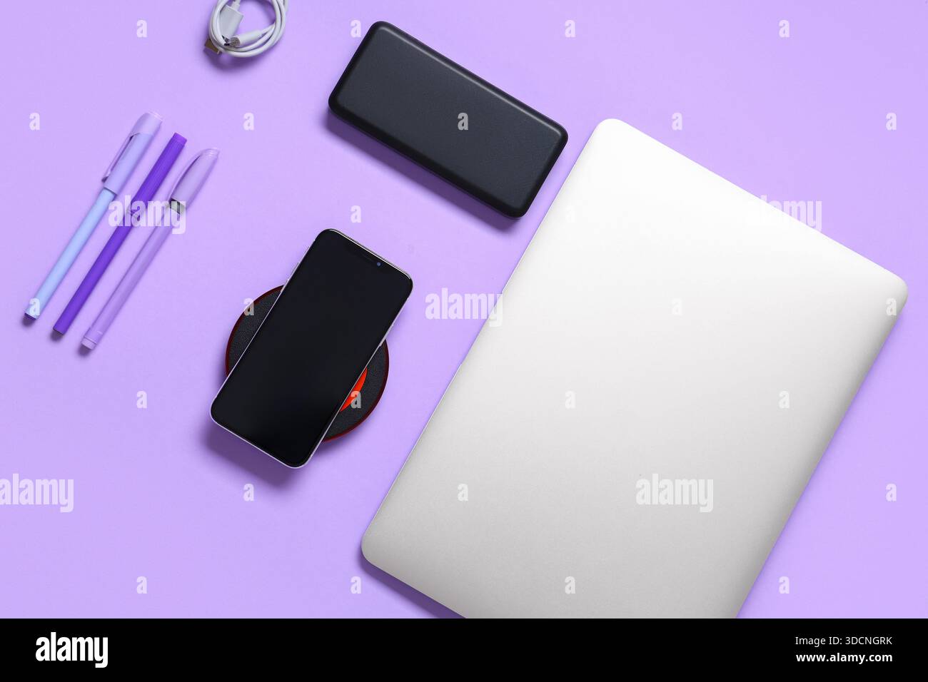 Composition with modern gadgets and pens on lilac background Stock Photo