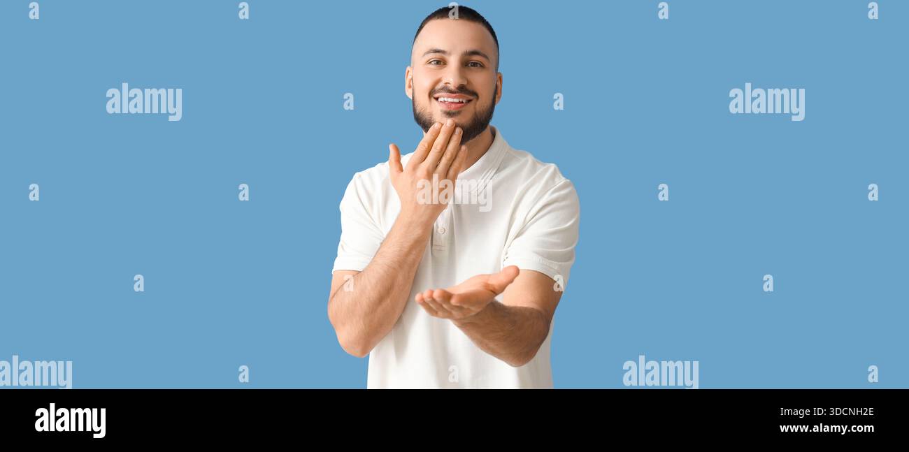 Young man using sign language on blue background Stock Photo