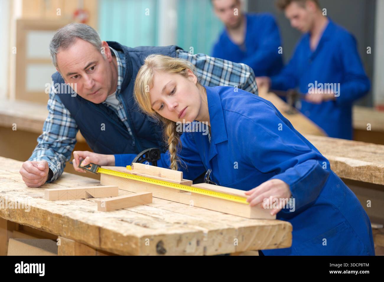 carpenter with female apprentice in workshop Stock Photo