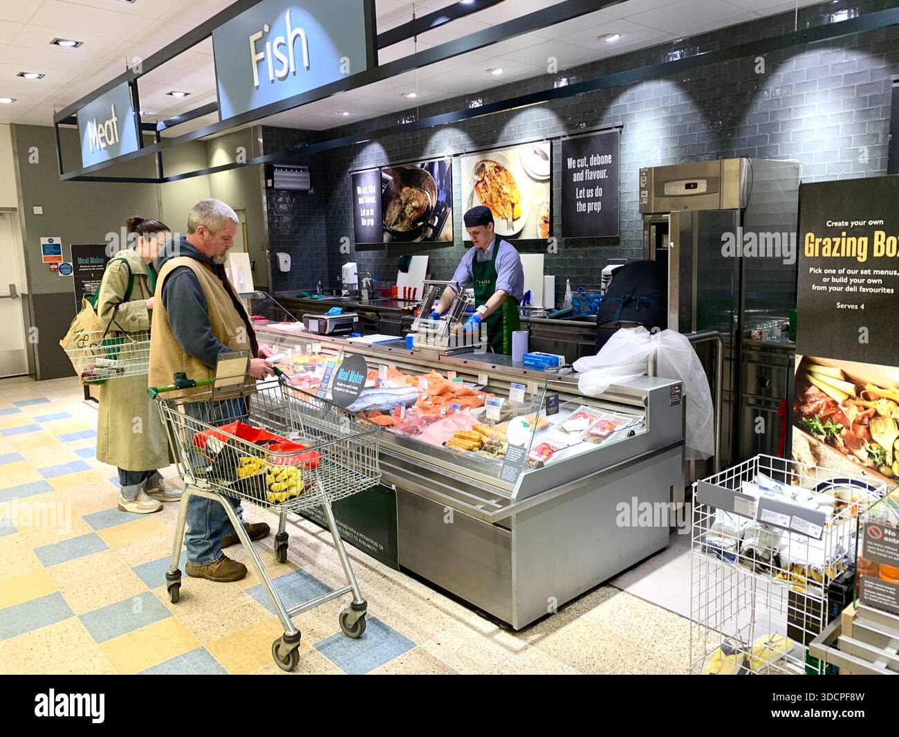 modern supermarket with automated retail technology fish counter and people shopping food counter exotic types in cabinet with staff serving - Smartphone Captured Stock Image