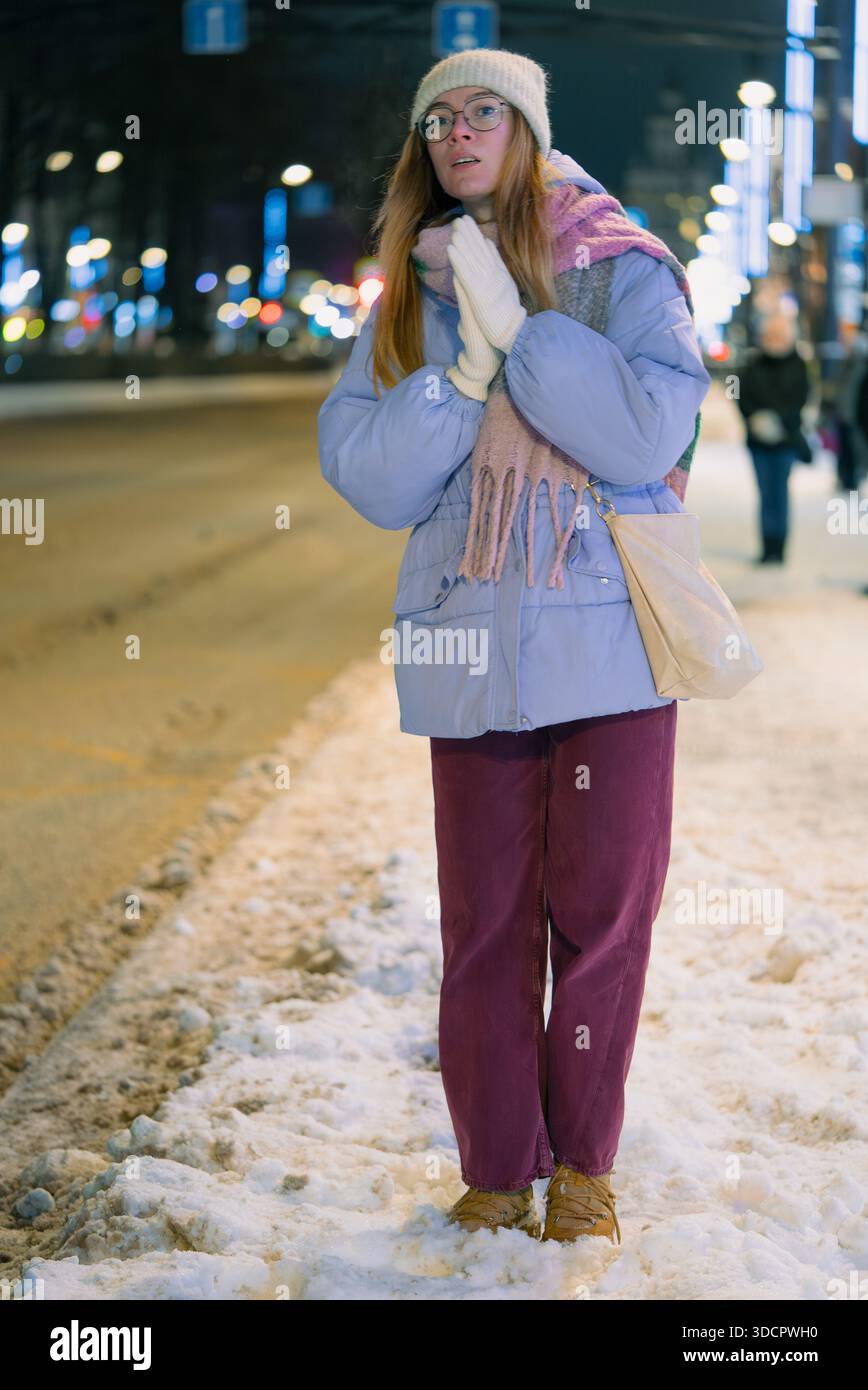 Young woman standing on a snowy sidewalk at night, waiting for public transportation at a city bus stop, wearing warm clothing and exhaling breath vap Stock Photo - Alamy Young woman standing on a snowy sidewalk at night, waiting for public transportation at a city bus stop, wearing warm clothing and exhaling breath vap Stock Photo - Alamy