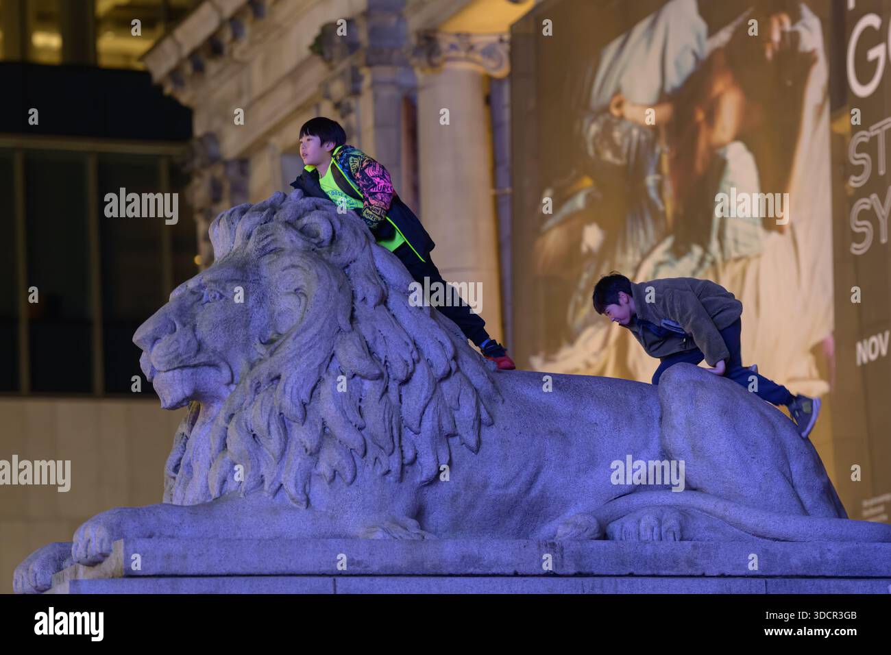 Children playing on stone lion Stock Photo