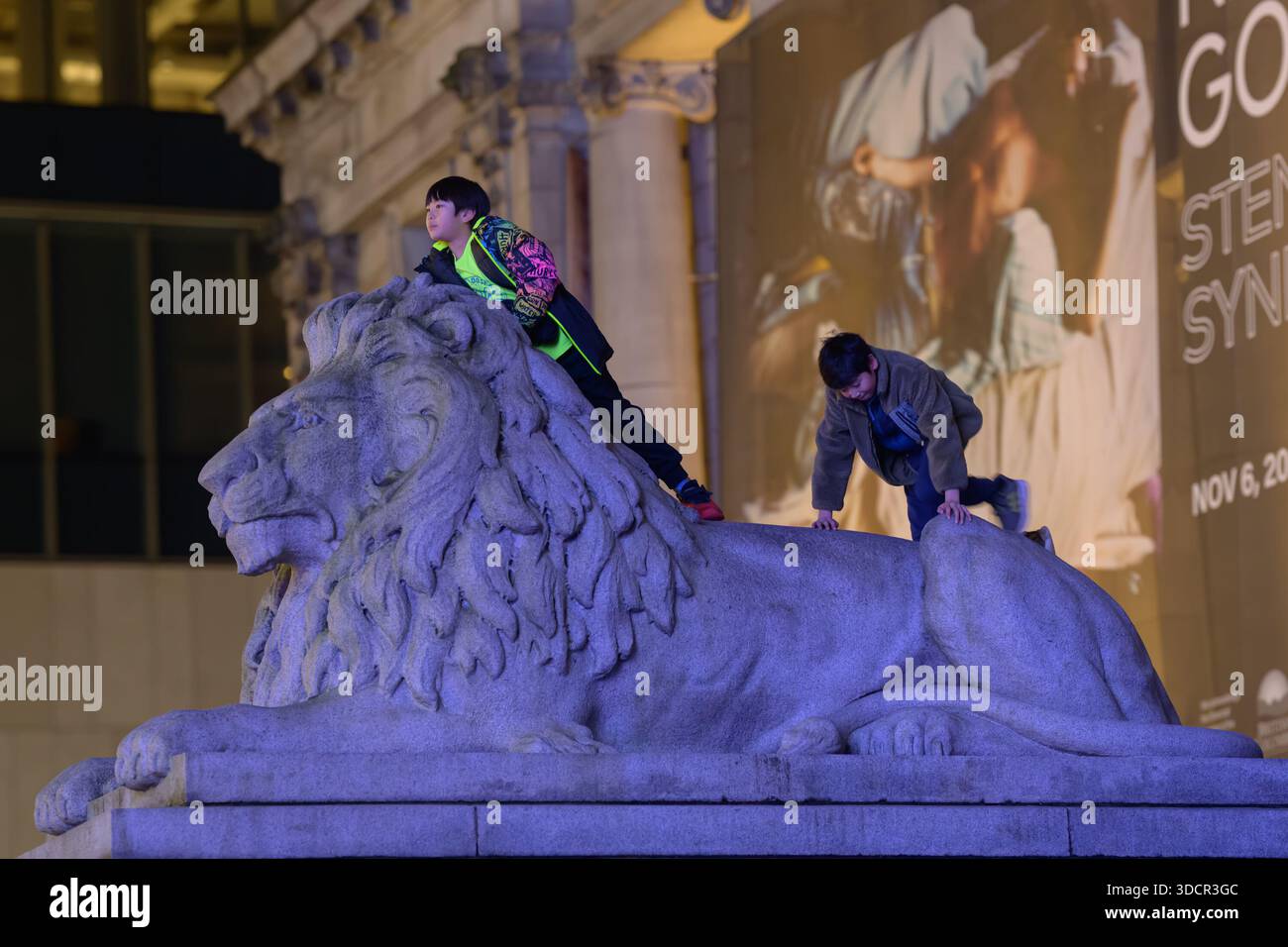 Children playing on stone lion Stock Photo