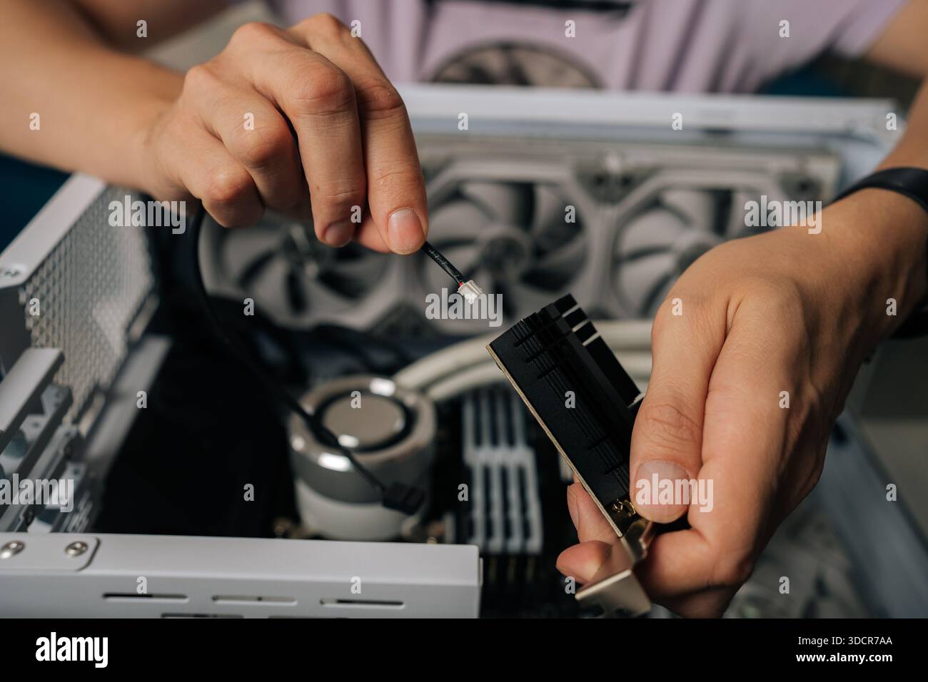 Skilled technician male hands inserting wireless network module inside computer tower, highlighting professional computer maintenance and hardware Stock Photo