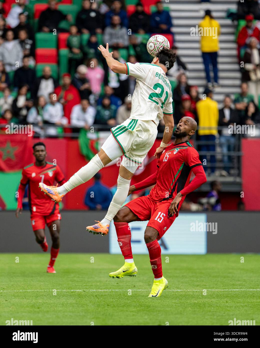 ramy-bensebaini-of-algeria-jumps-for-the-ball-with-salah-adel-of-sudan