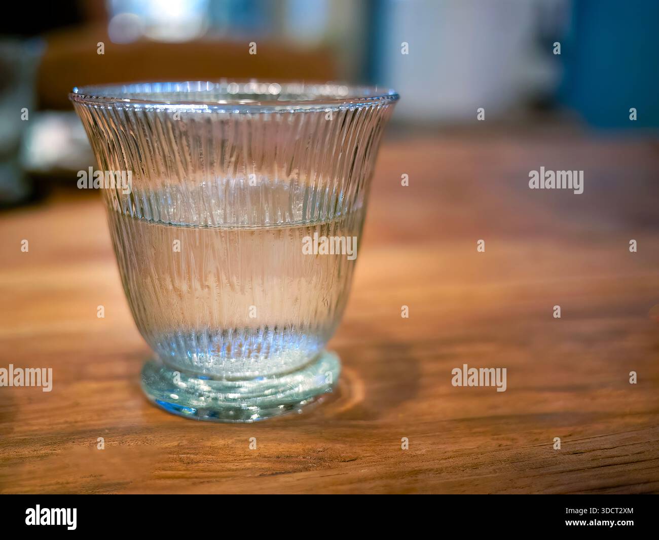 A glass of fresh, clear drinking water served in stylish ribbed or fluted  tumbler. The beverage convey purity, hydration, and cozy dining atmosphere  Stock Photo - Alamy