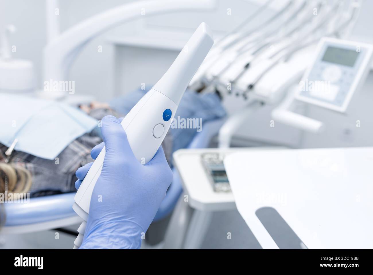 Gloved hand holds intraoral 3D scanner for digital impression and CAD CAM workflow in modern dental office Stock Photo