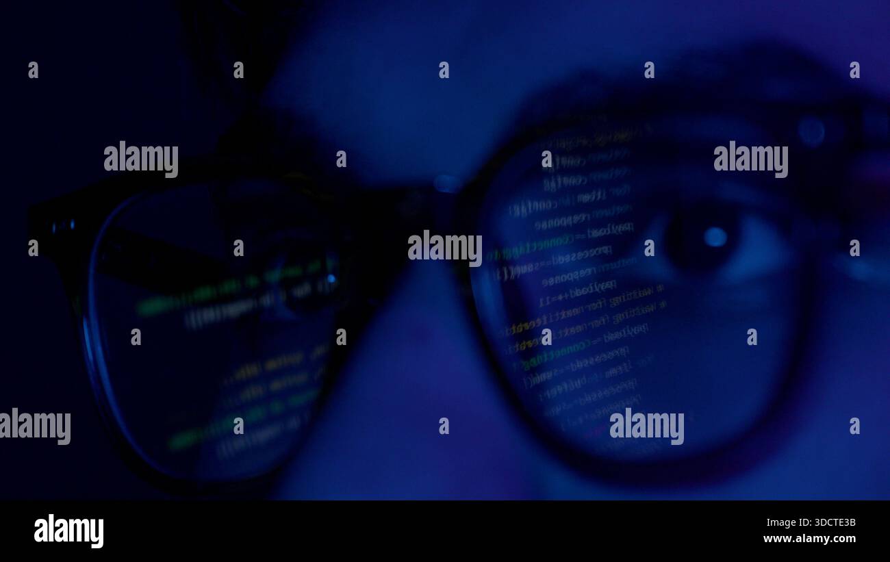Close up of man's face with binary code reflection on glasses Stock Photo