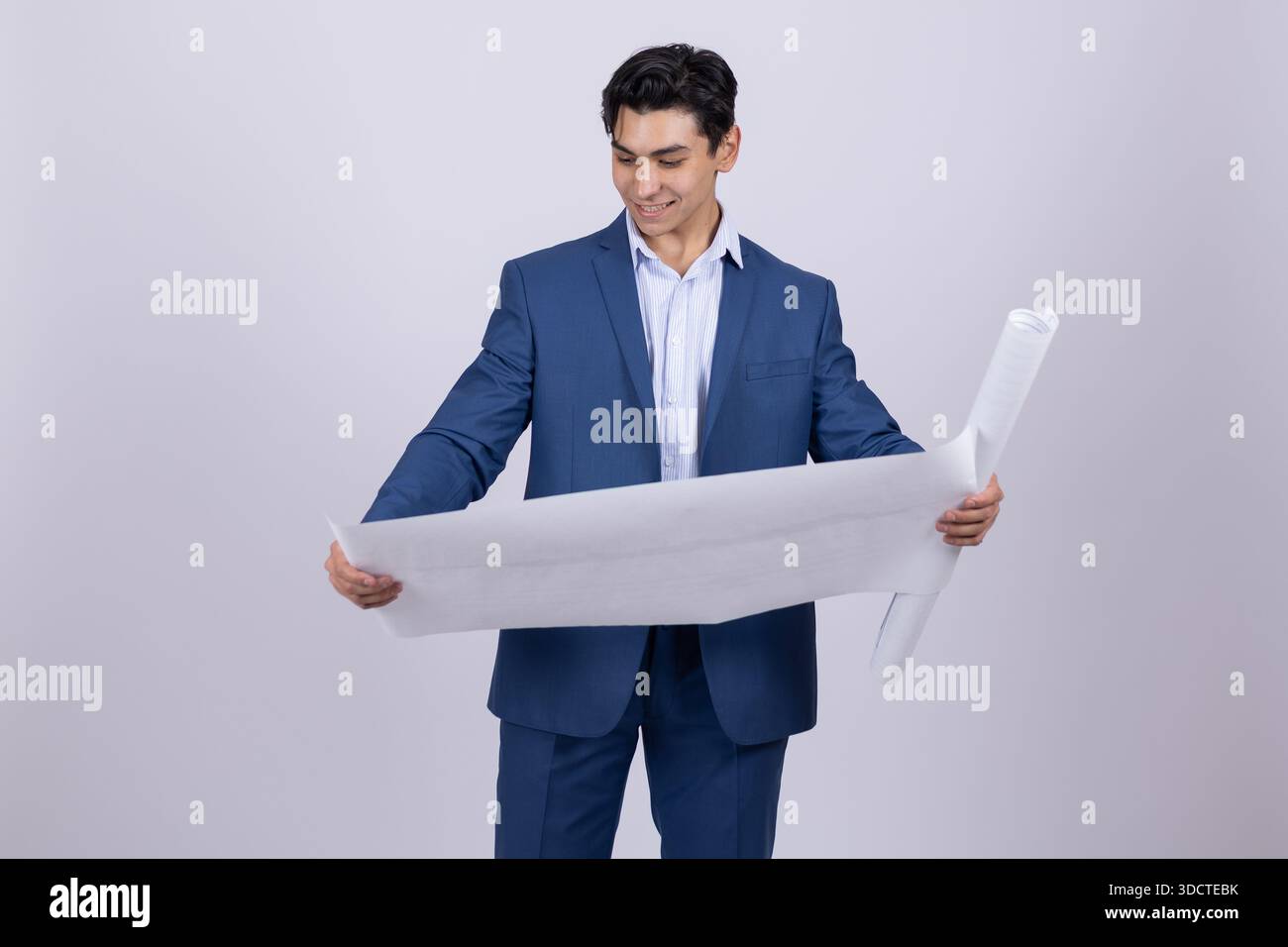 Architect in blue suit looking at rolled blueprint Stock Photo