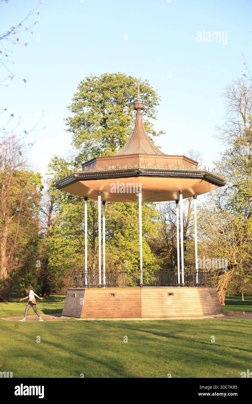 A woman walks by the bandstand at Hyde Park in London. Stock Photo