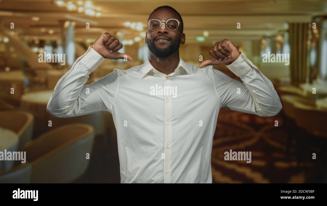 Man pointing thumbs to chest while smiling, wearing glasses and white ...