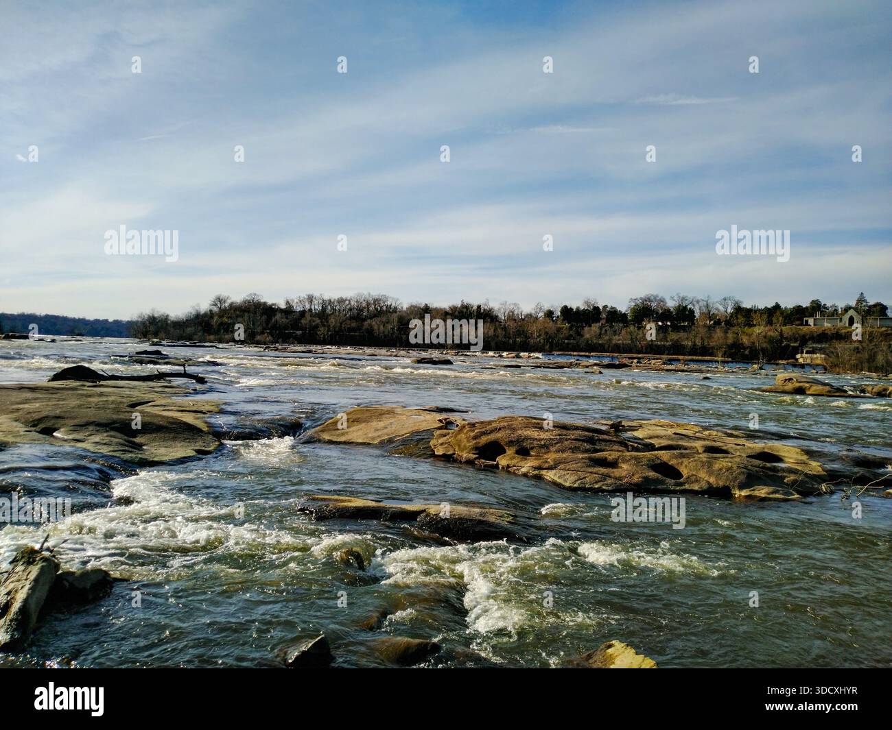 Powerful river current flowing over large smooth rocks Stock Photo
