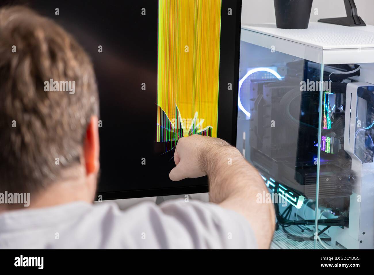 Rear view of a person's hand indicating damage on a desktop computer ...