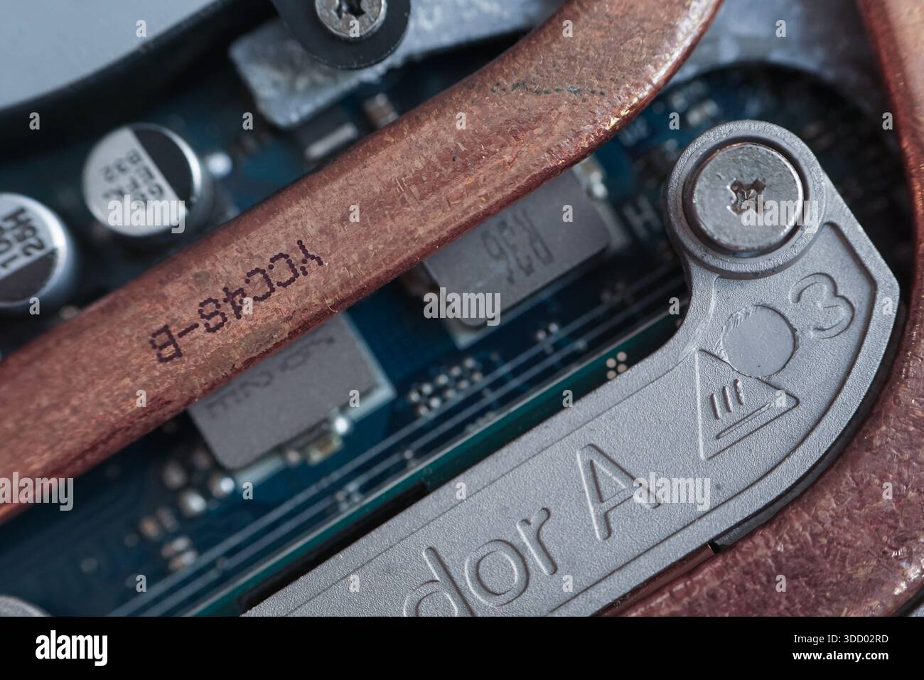 Extreme close-up of a copper thermal heat pipe and mounting screw inside a laptop. Visualizes thermal management and hardware assembly. Stock Photo