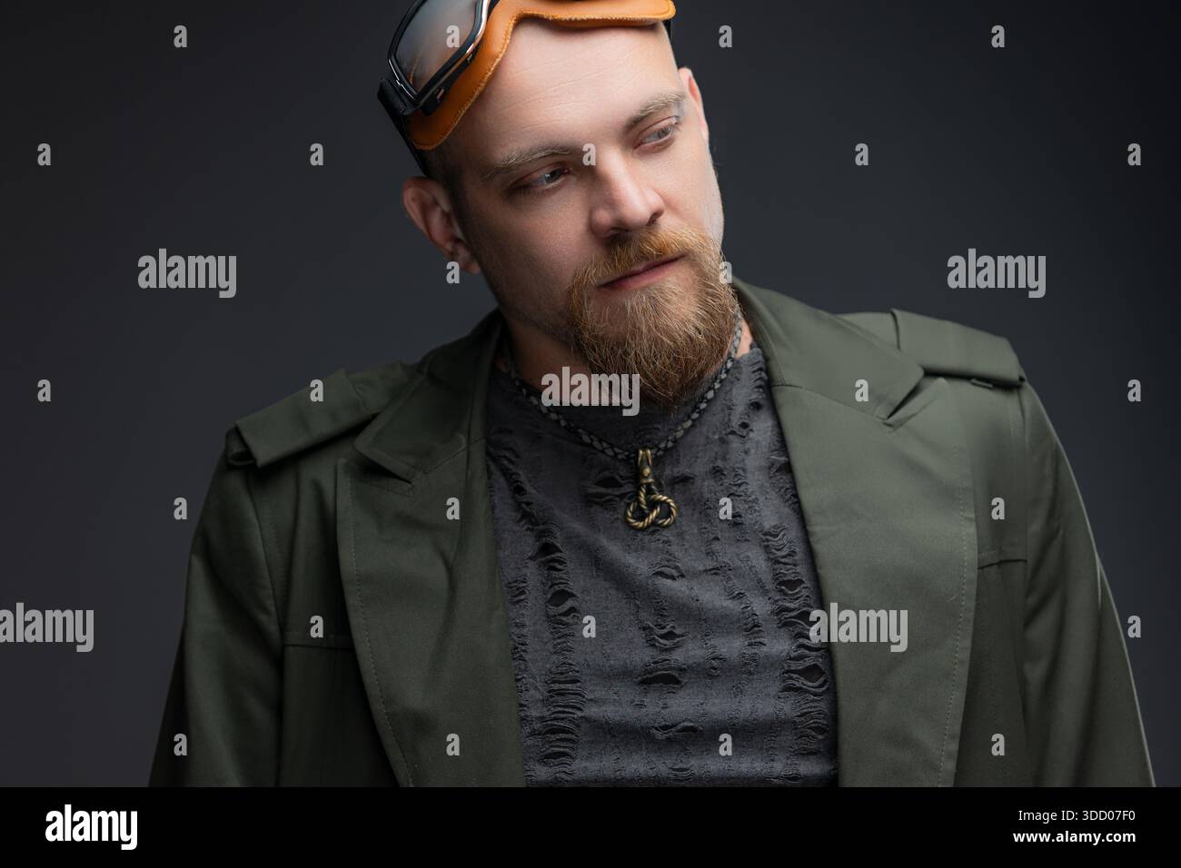 Bald man in dystopian raincoat with textured holes and goggles