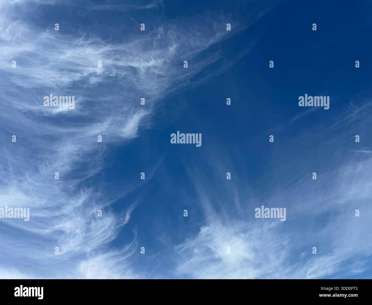 Blue sky with gentle wispy clouds Stock Photo