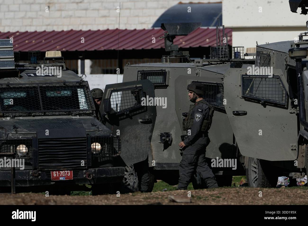 Members of the Israeli forces stand next to their armored vehicles ...