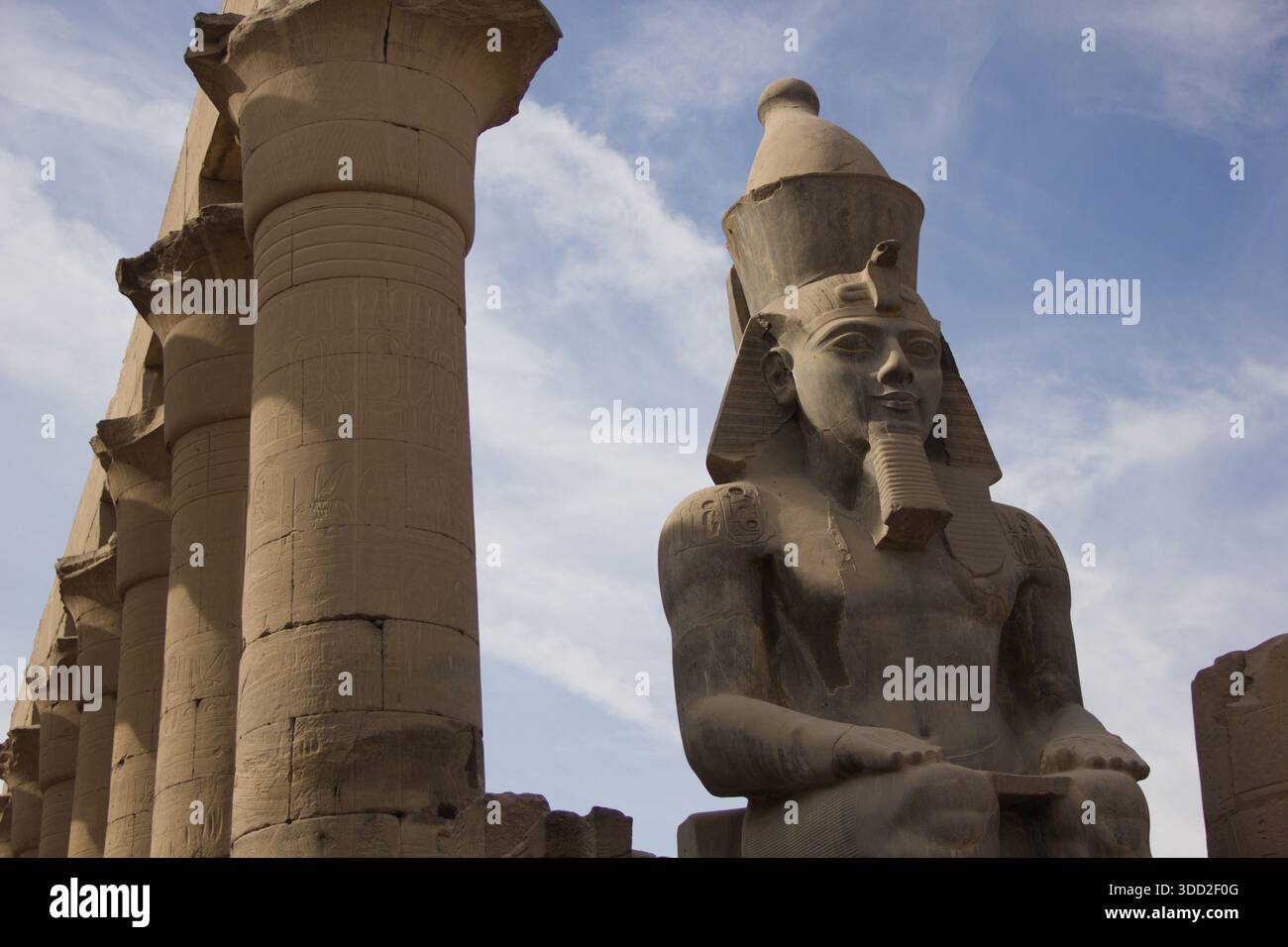 Colossal statue of an ancient Egyptian pharaoh with massive temple ...