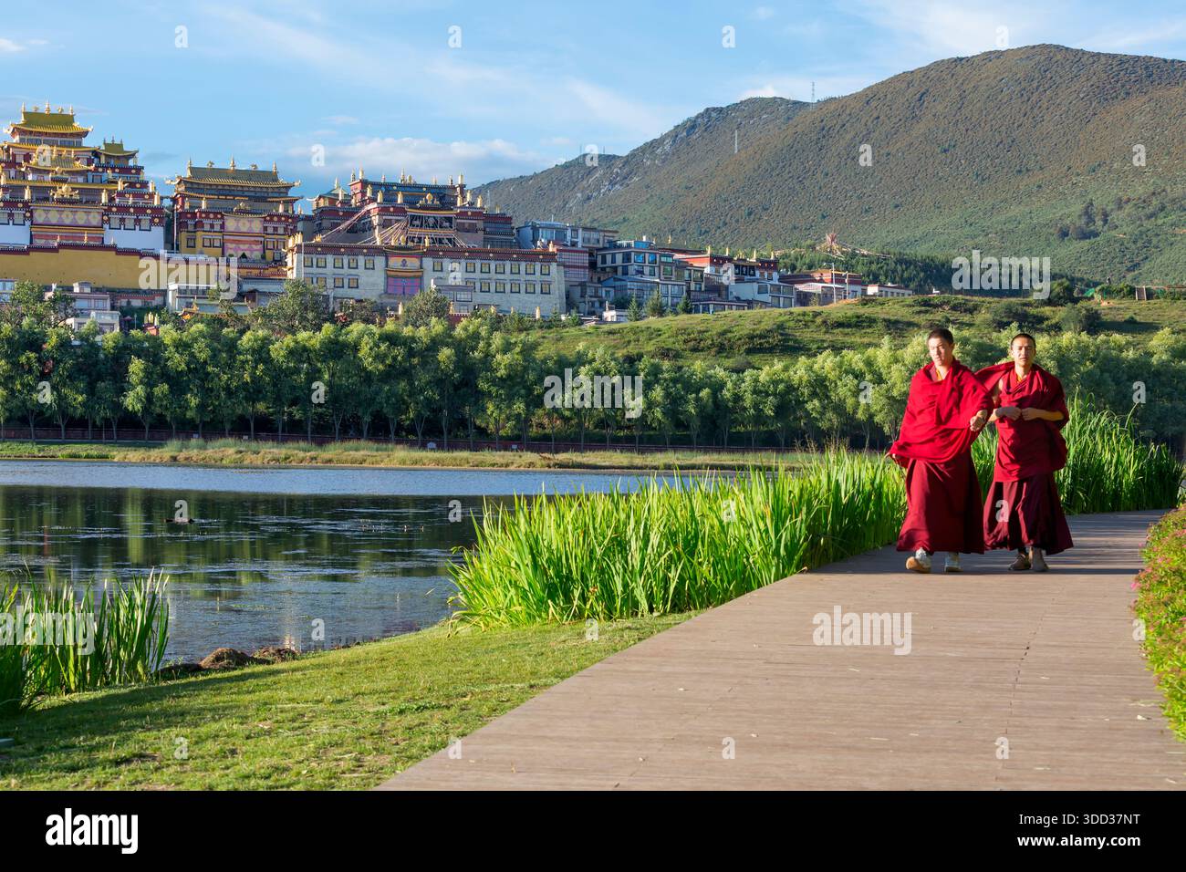 SHANGRI LA, CHINA - August 27 , 2025: Tibetan monks walking in front of the Songzanlin monastery, also known as Ganden Sumtseling Gompa in Zhongdian, Stock Photo