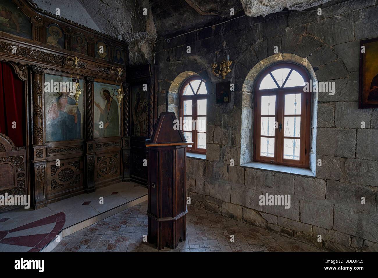 Low-light interior of Basarbovo Monastery stone chapel showing arched ...