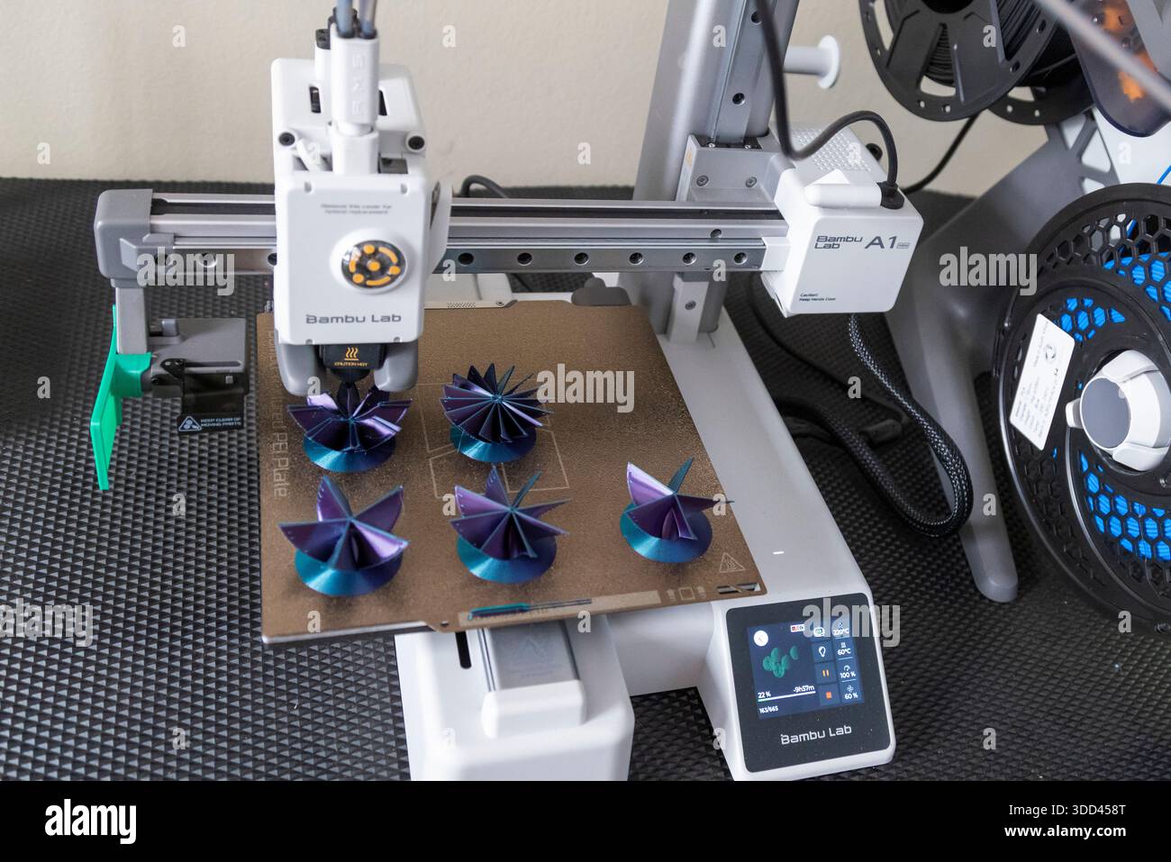 Five complex shaped Christmas decorations during printing on a Bambu Lab 3D printer Stock Photo