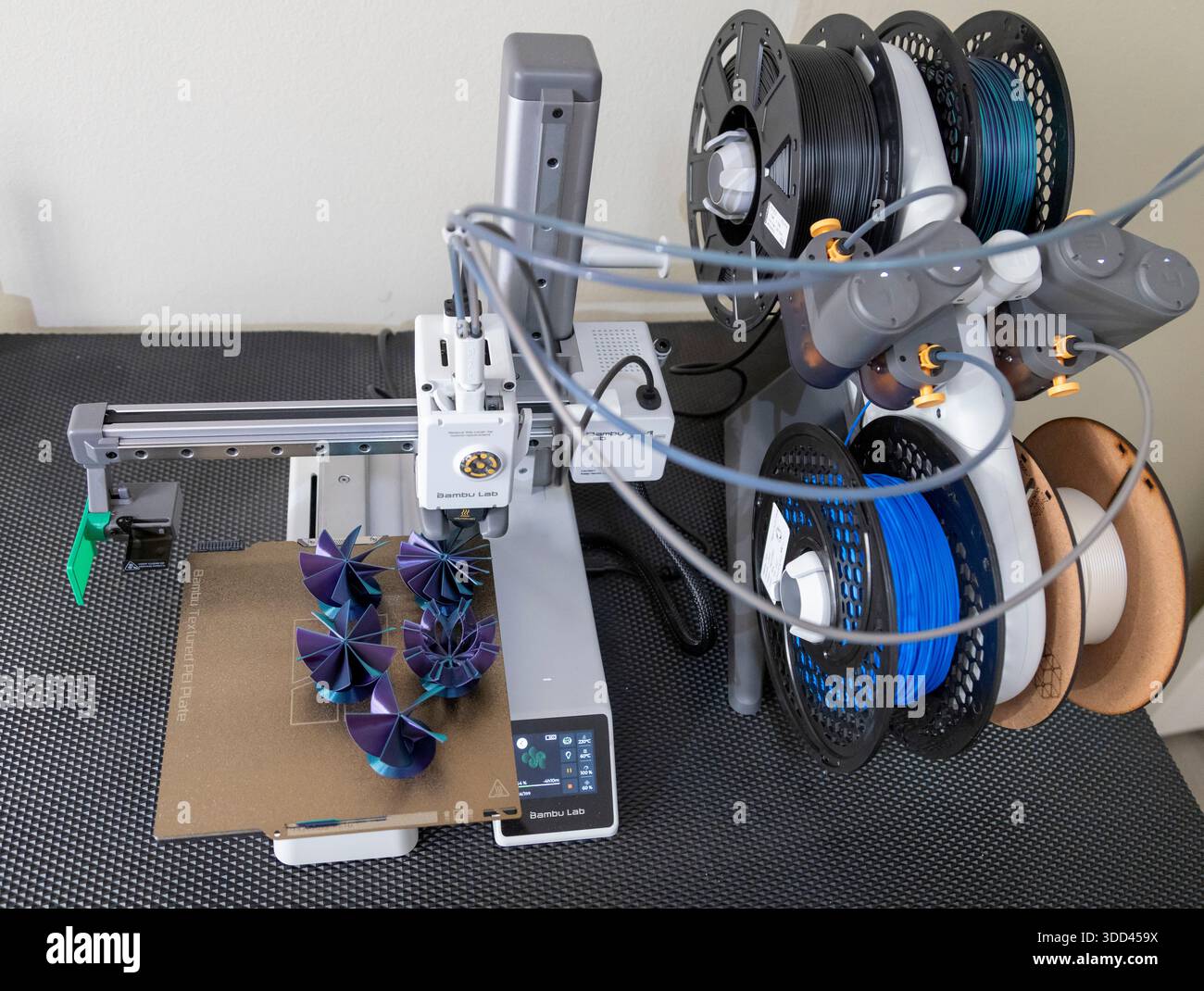 Five complex shaped Christmas decorations during printing on a Bambu Lab 3D printer Stock Photo