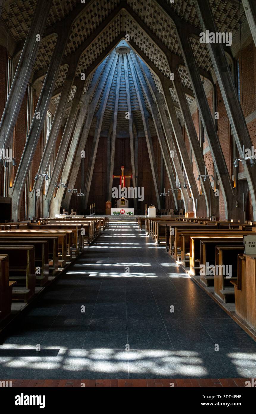 Interior of a modern church with long central aisle, wooden pews and ...