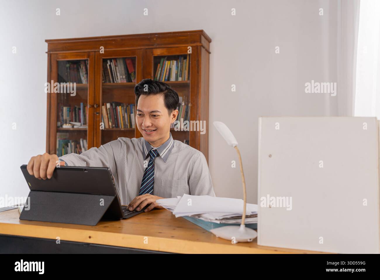 Finance specialist arranges documents on clean desk environment Stock Photo