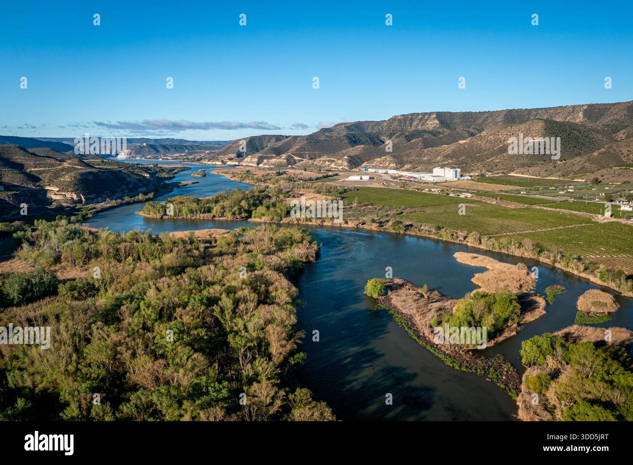 Wide river winding through a scenic valley, lush trees and fields, La ...