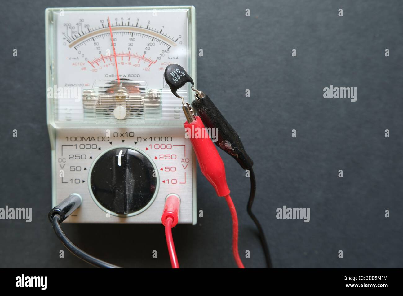 The value of a thermistor (NTC) is measuring with an ohmmeter. Focused on thermistor and probes. Stock Photo