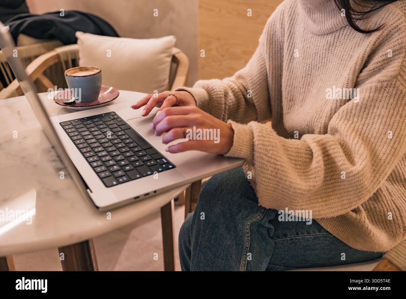 Woman freelancer working on laptop with coffee Stock Photo