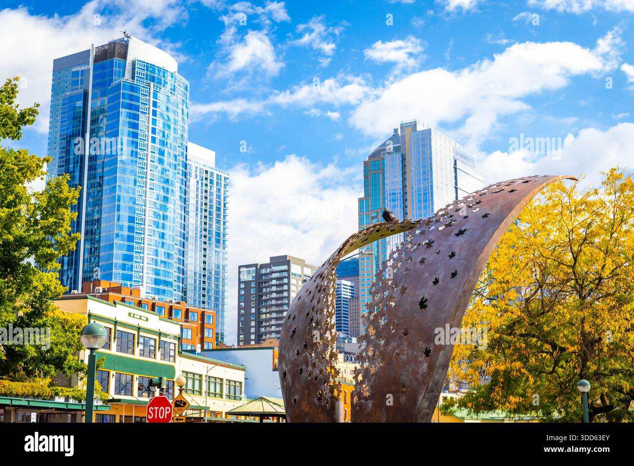 Modern commercial buildings and skyscrapers line a dense downtown street in Seattle, Washington, illuminated by a bright summer sun. Stock Photo
