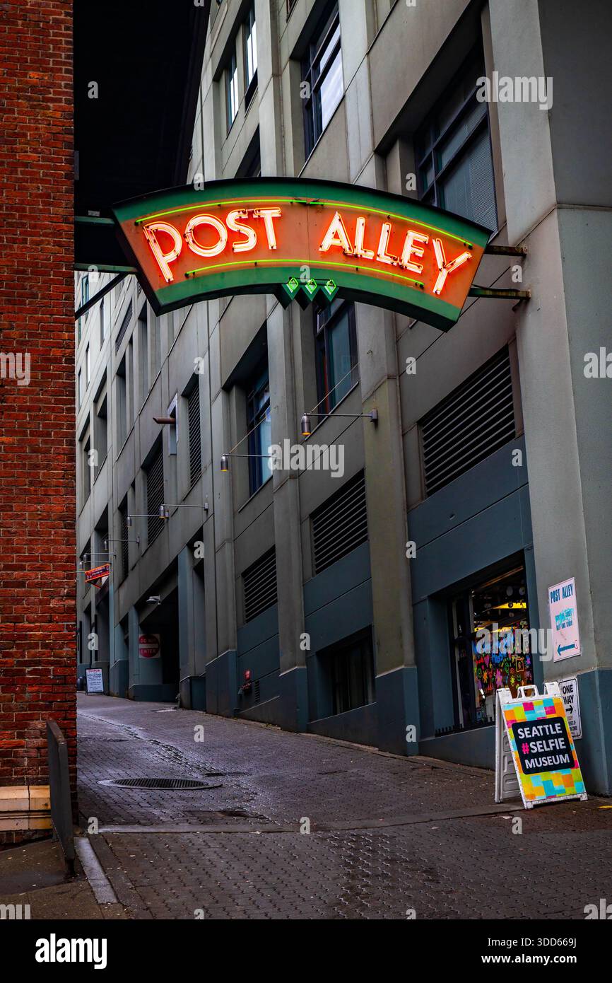 Seattle, WA, USA - September 21, 2025: The famous, glowing Post Alley neon sign brightly marks the entrance to the historic alley near Pike Place Mark Stock Photo