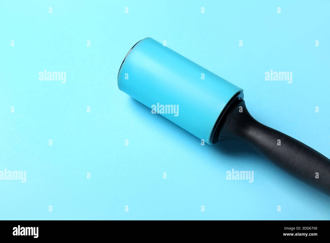 Lint roller on blue background Stock Photo