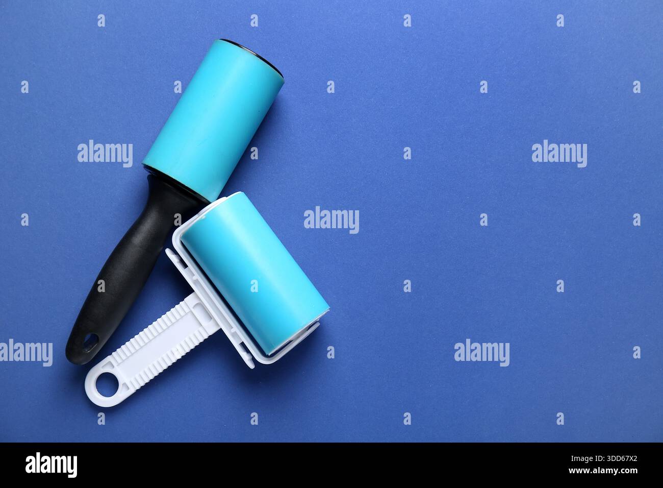 Different lint rollers on blue background Stock Photo