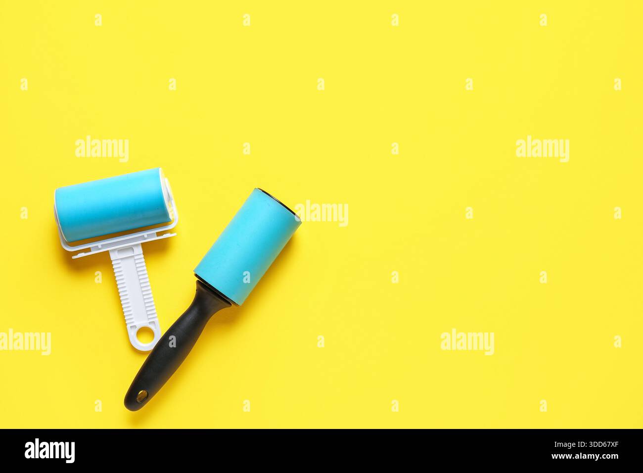 Different lint rollers on yellow background Stock Photo