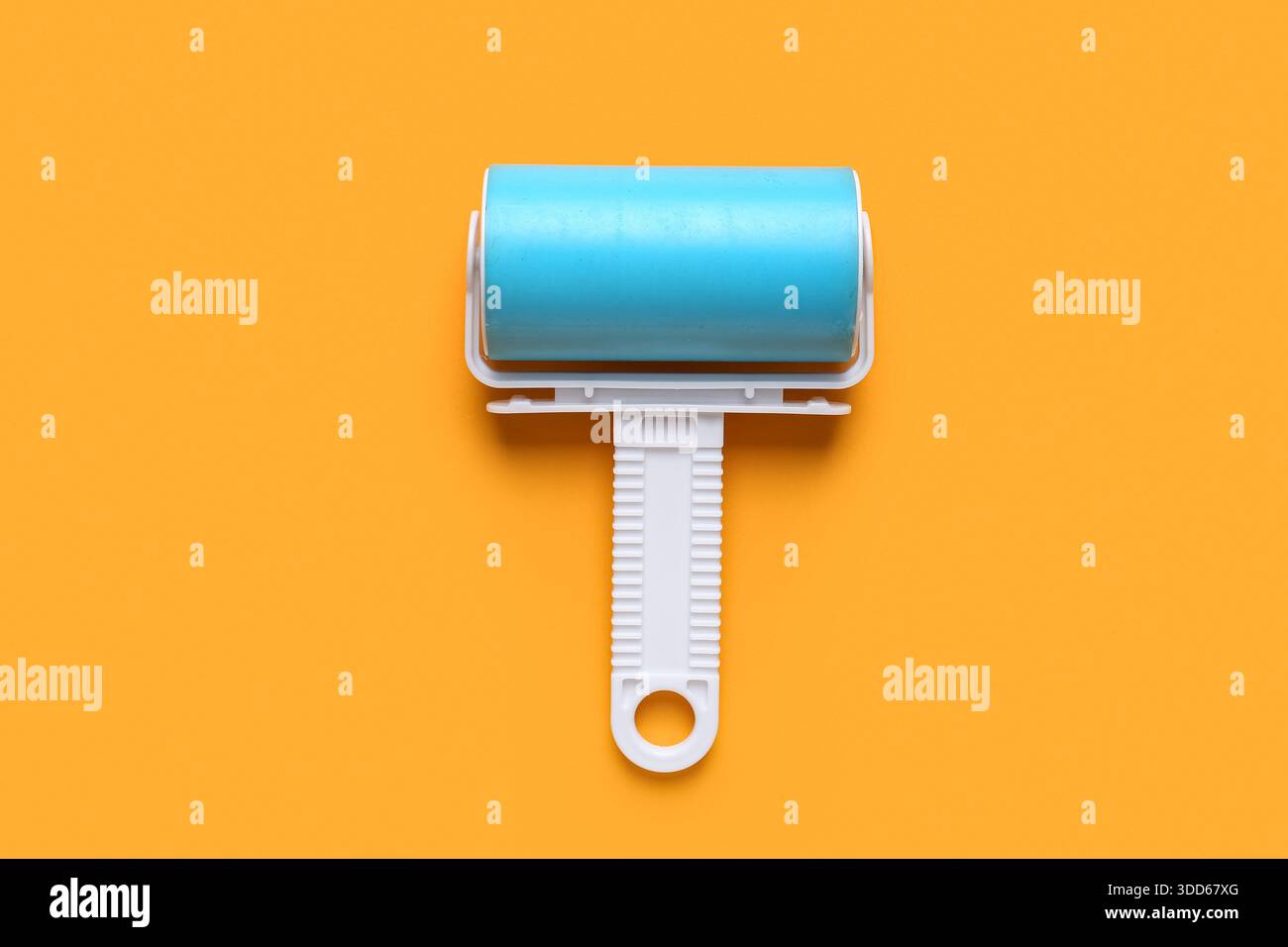 Lint roller on orange background Stock Photo
