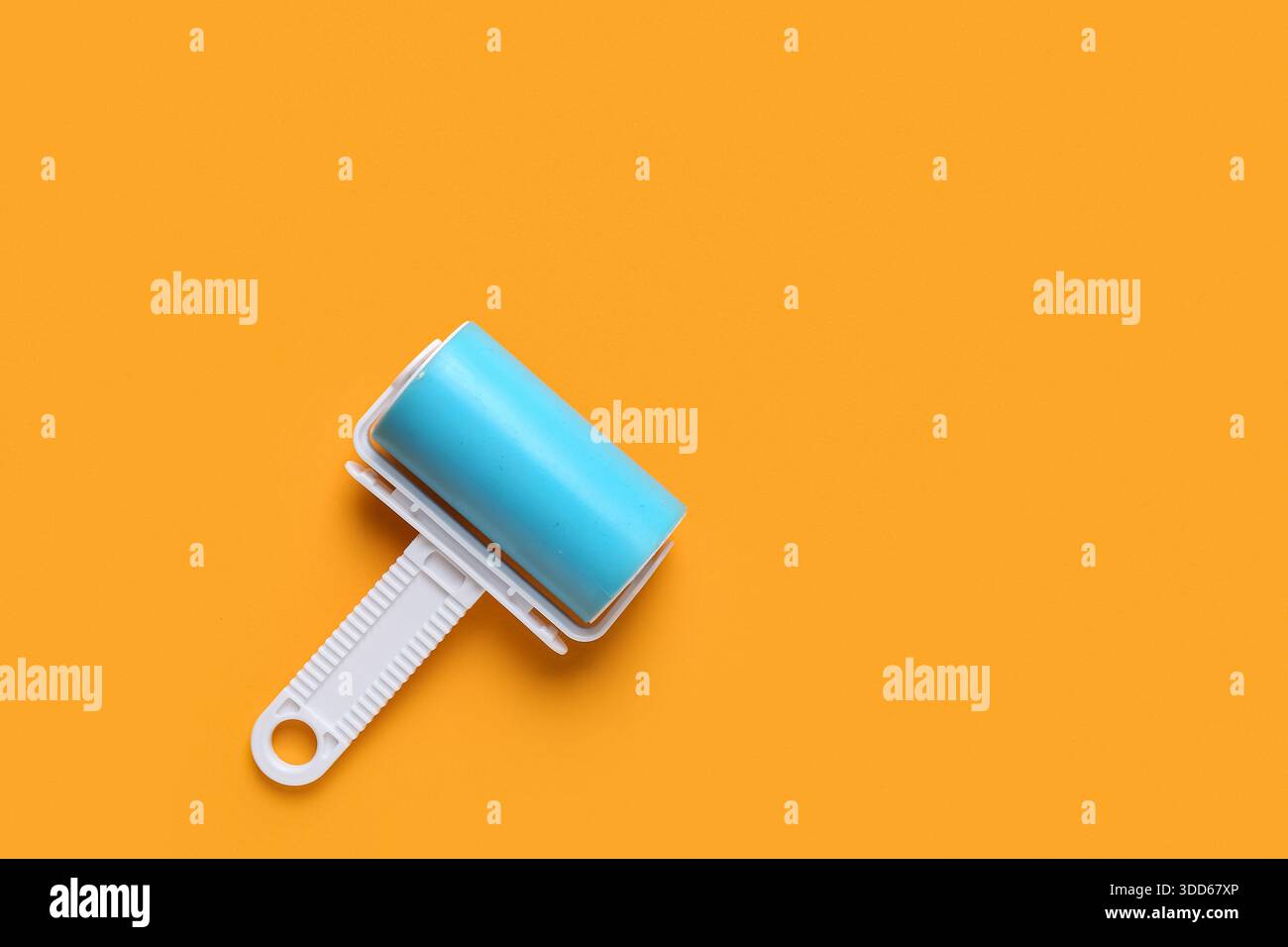 Lint roller on orange background Stock Photo