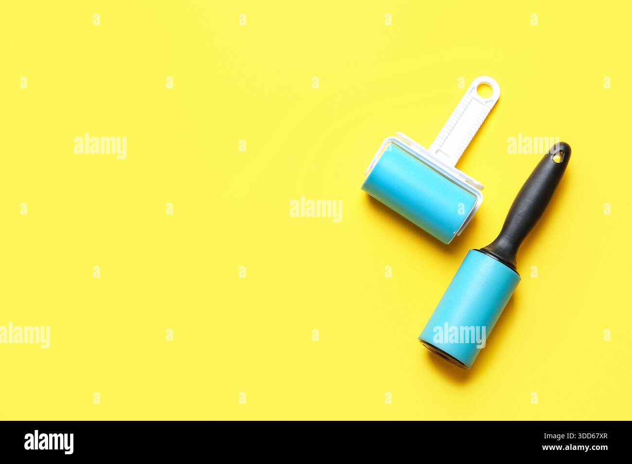 Different lint rollers on yellow background Stock Photo