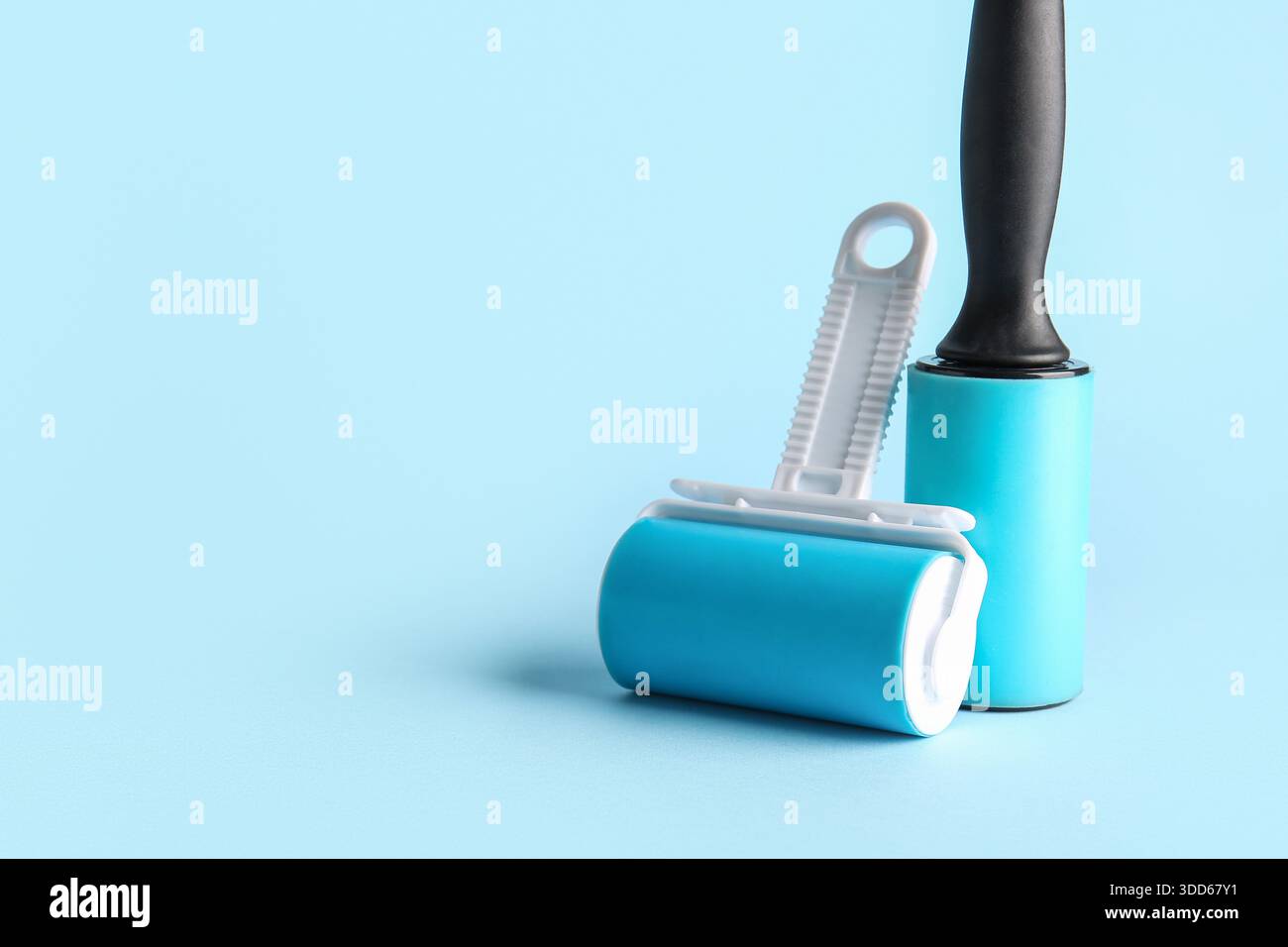 Lint rollers on blue background Stock Photo