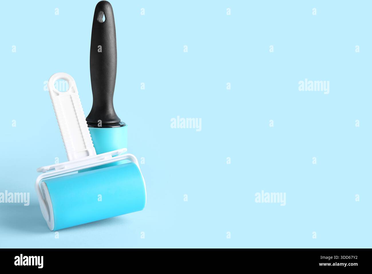 Lint rollers on blue background Stock Photo