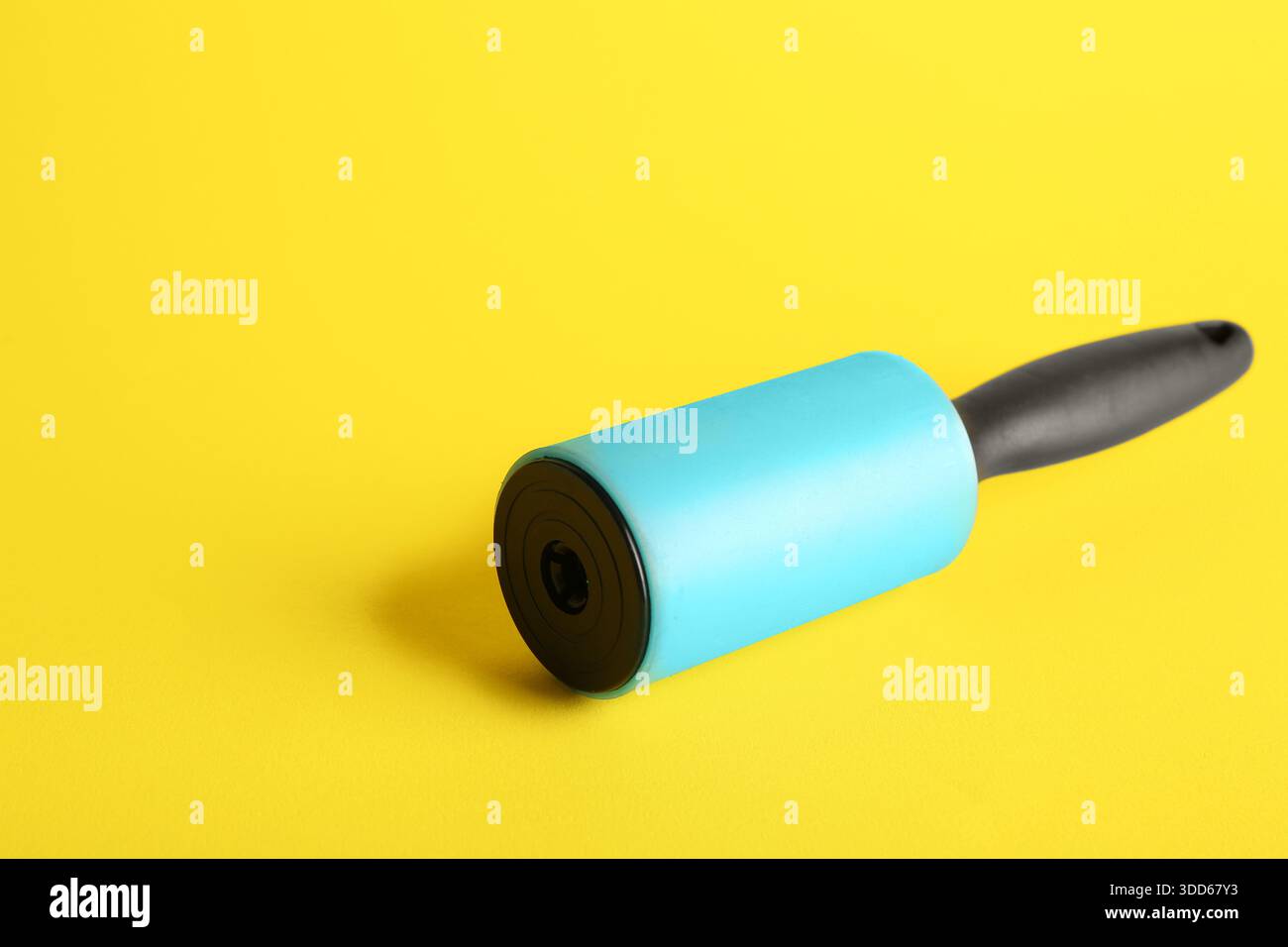 Lint roller on yellow background Stock Photo