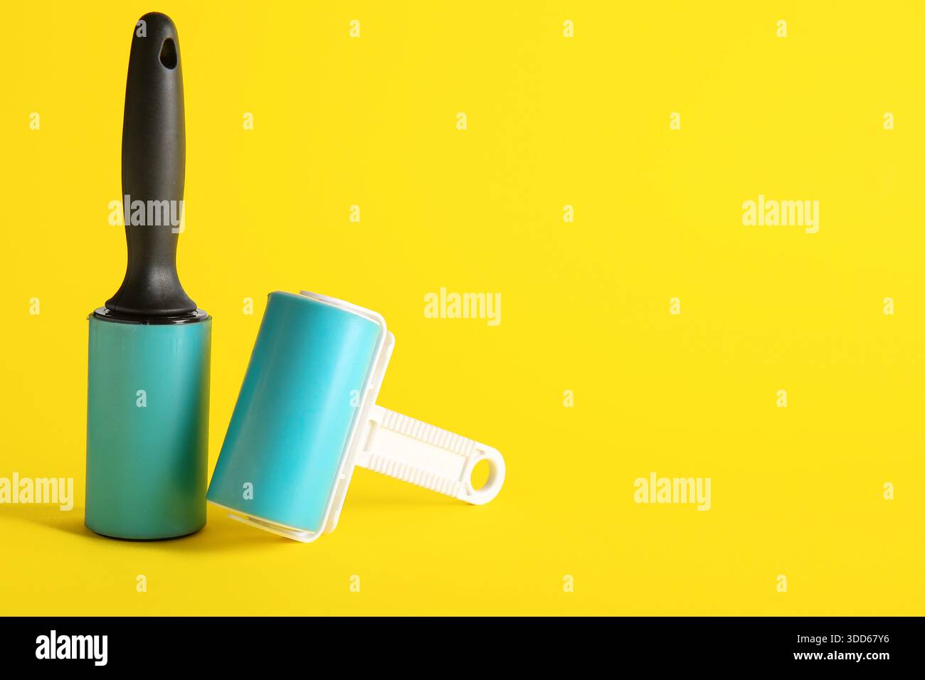 Different lint rollers on yellow background Stock Photo