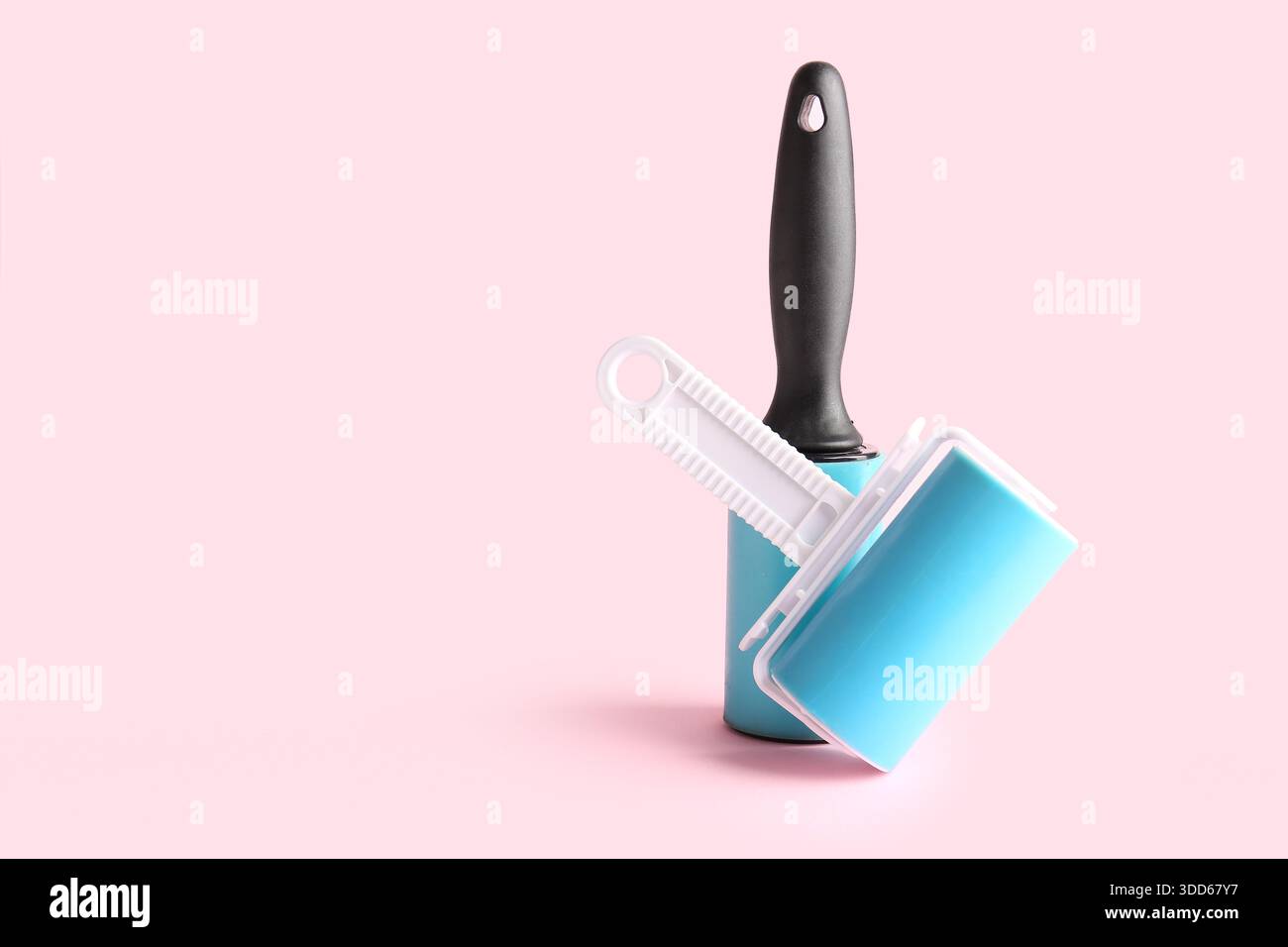 Different lint rollers on pink background Stock Photo
