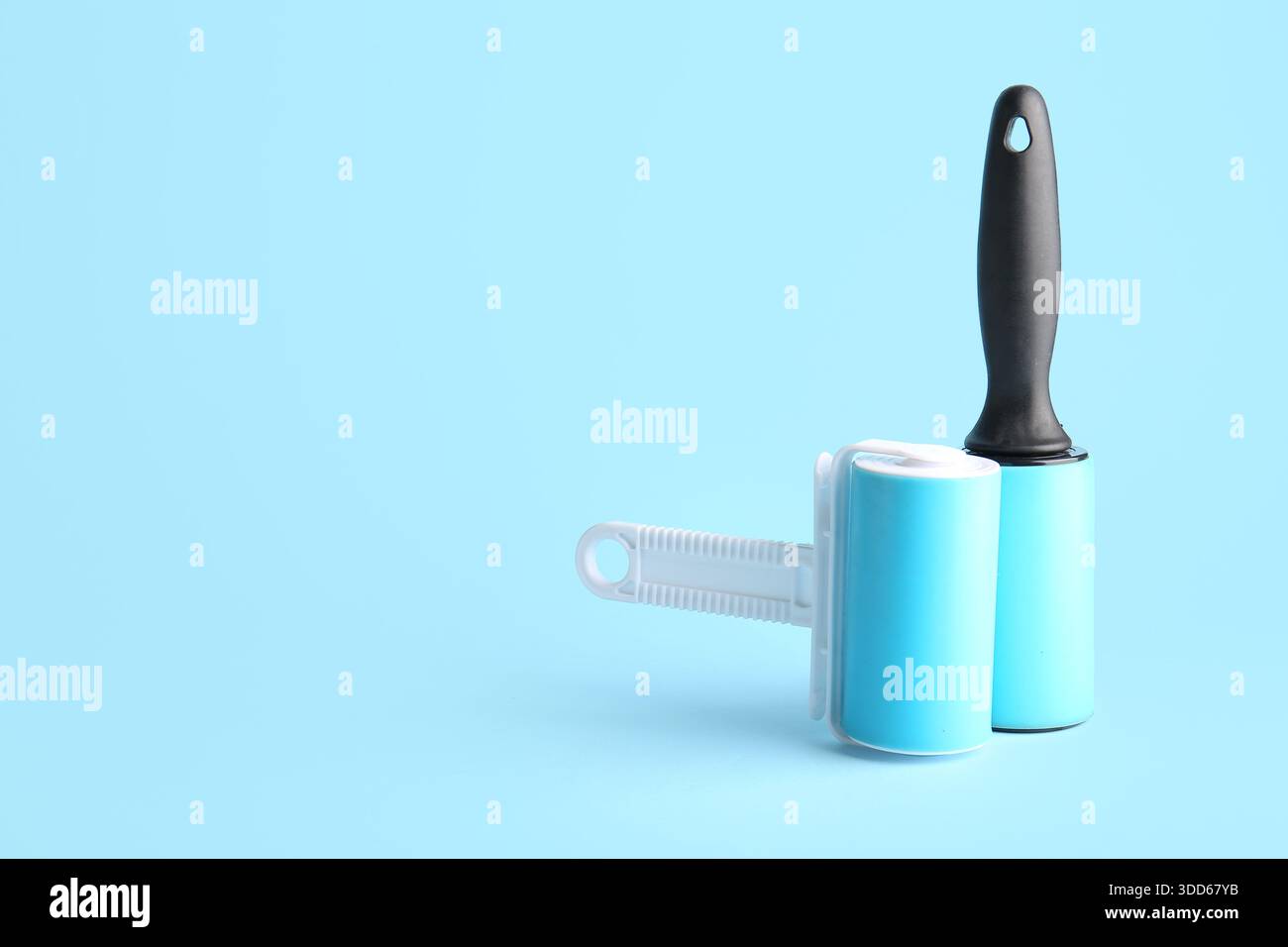 Lint rollers on blue background Stock Photo