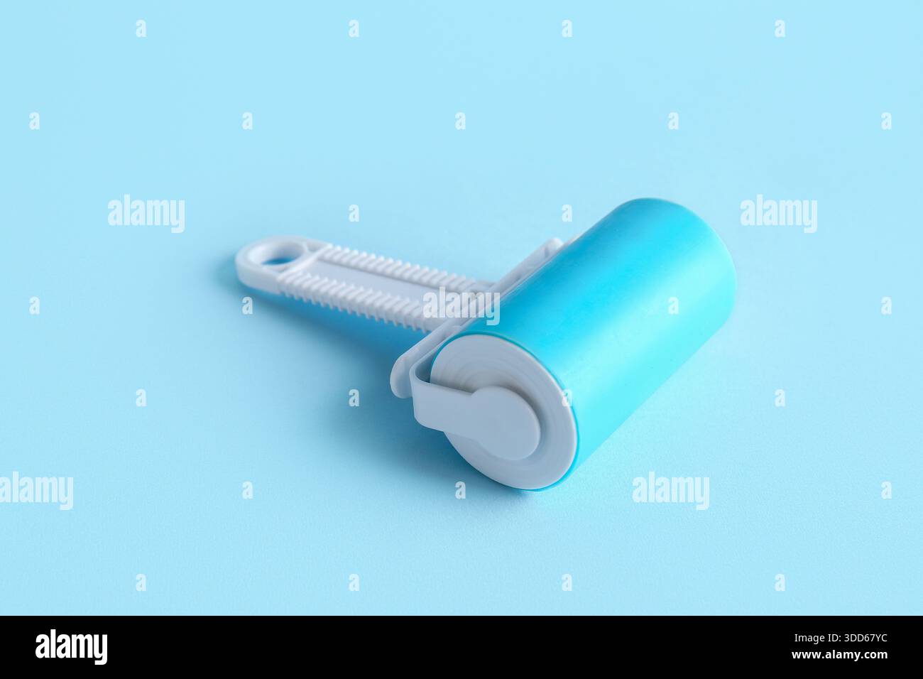 Lint roller on blue background Stock Photo